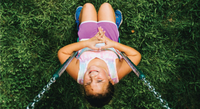 young girl looking up from swing