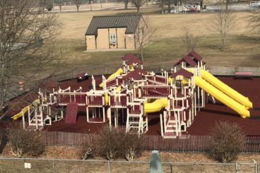 red and yellow custom commercial playset in a park