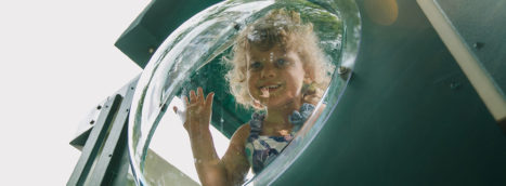 little girl peeking out of the bubble panel
