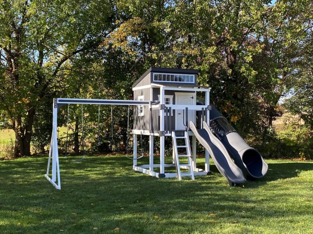 a vinyl playset with 2 slides and an elevated playhouse