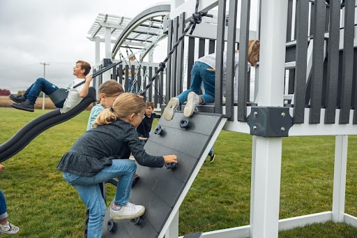 Kids playing on a playset. When asking yourself how to get kids off screens, one answer is to invest in a Swing Kingdom playset.