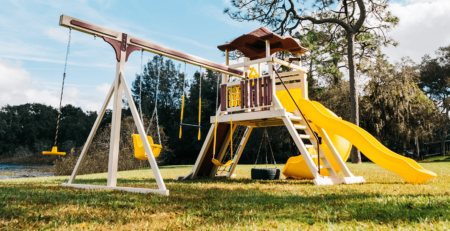 Red and yellow kastle tower playset with a variety of swing options