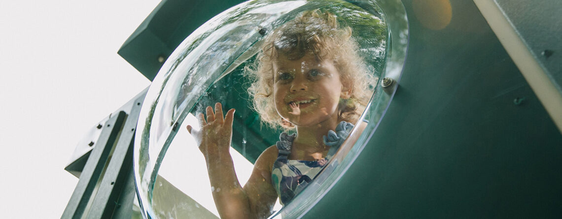 little girl peeking out of the bubble panel
