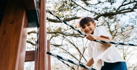 a boy playing on a playset